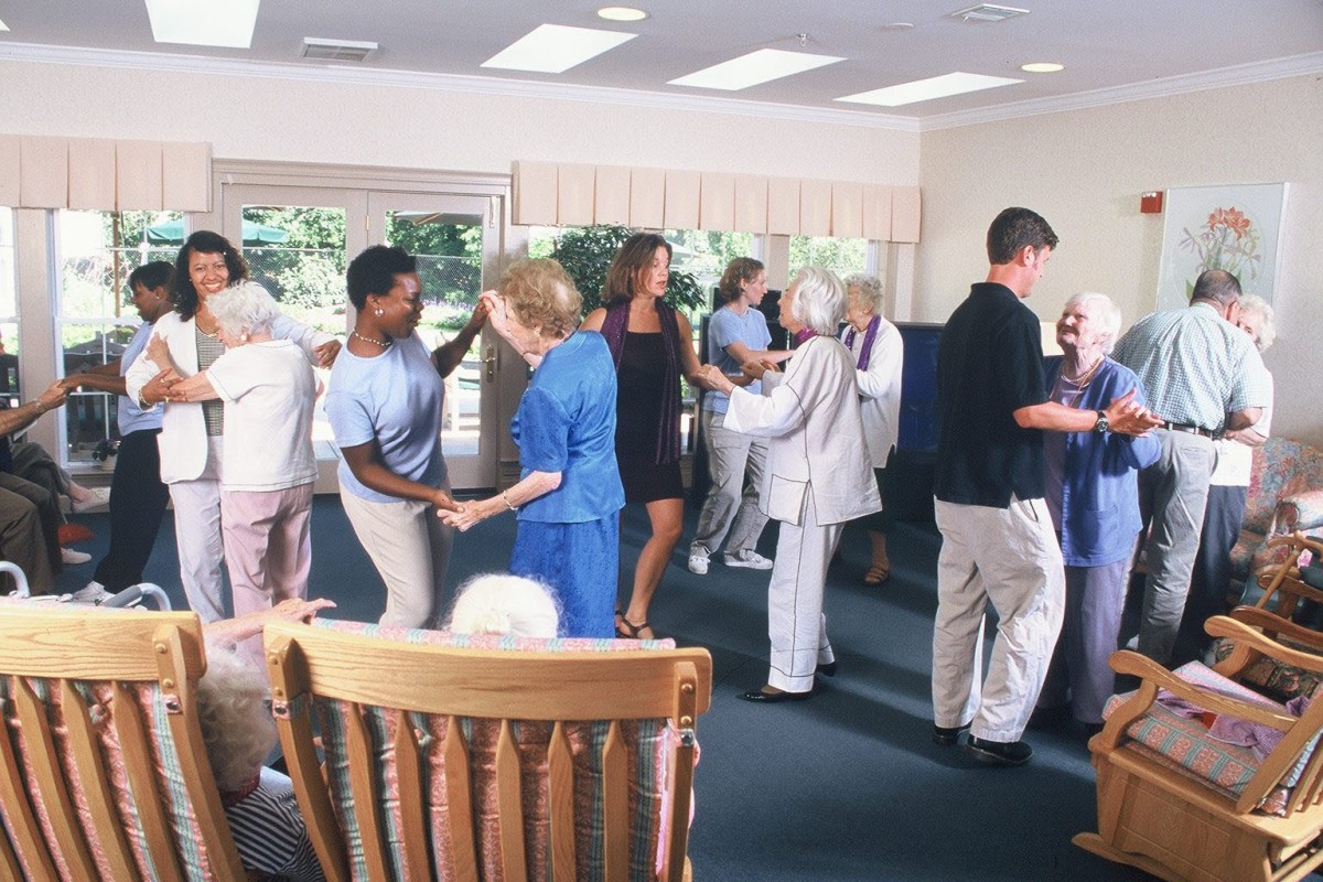 A group of seniors enjoying a dance activity in a community center.