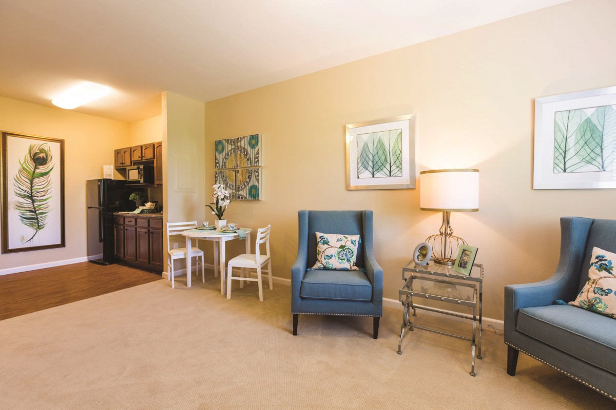A cozy living room with an armchair, a small dining table, and decorative elements.