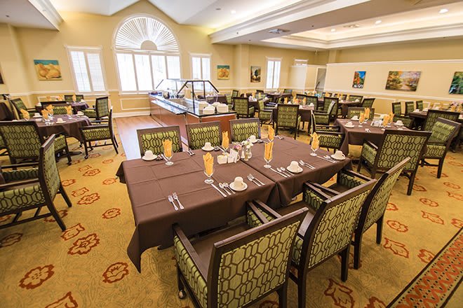 An elegant dining room with neatly arranged tables and chairs.