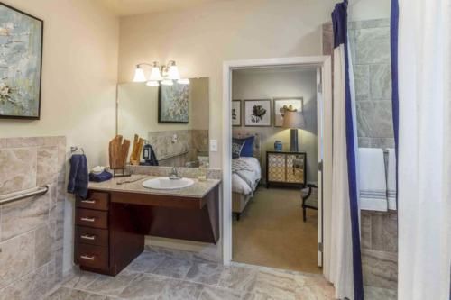 A view from a bathroom into an adjacent bedroom, showcasing interior design elements like a sink area and stylish decor.