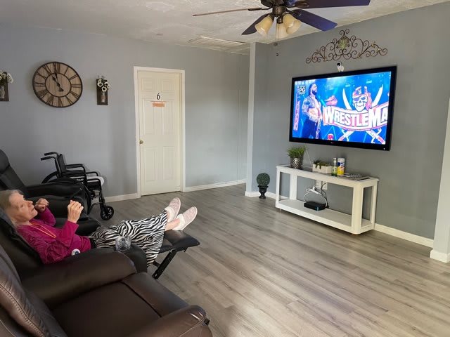 A cozy living room with a person relaxing on the sofa, watching TV.