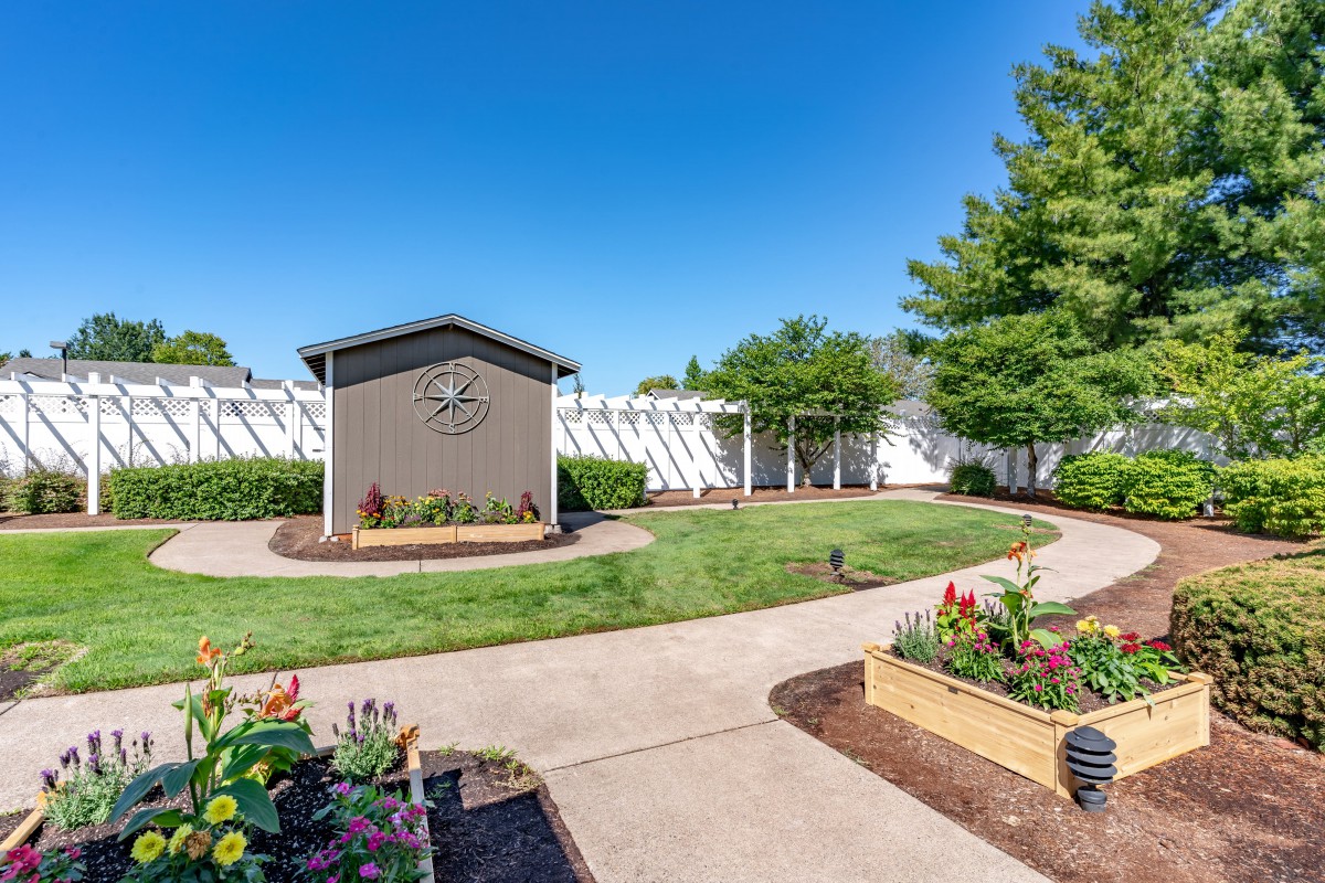 A beautifully landscaped garden with a path and vibrant flowers under a clear blue sky.