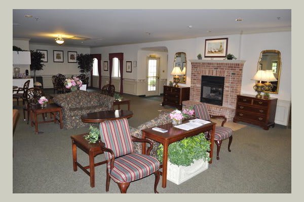 A cozy living room with traditional furniture and a brick fireplace.