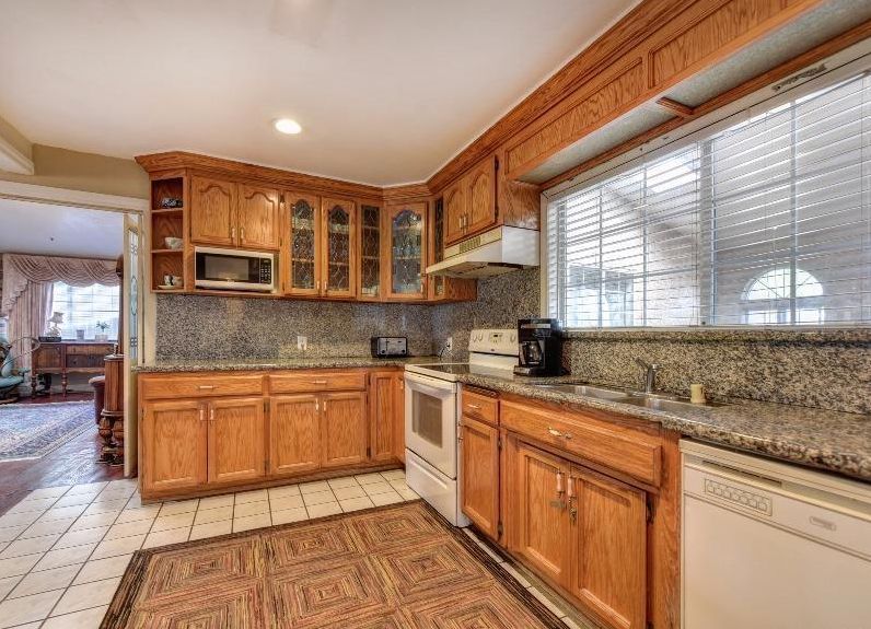 A spacious kitchen with wooden cabinets and modern appliances.