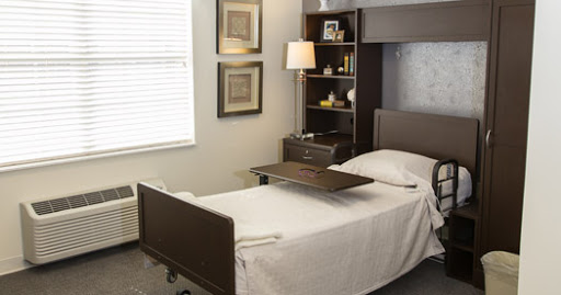 A well-furnished patient room featuring a hospital bed, shelving, and stylish decor.