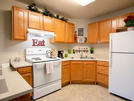 A cozy kitchen with wooden cabinets, a stove, and refrigerator.