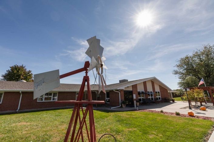 A sunny day at a school with a windmill in the foreground.