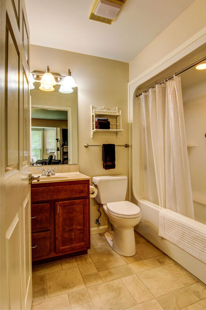 A cozy bathroom with a vanity, toilet, and a bathtub with a shower curtain.