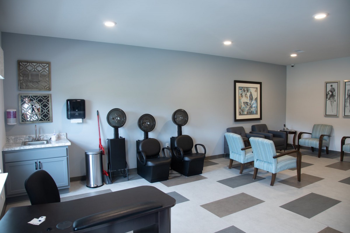 A modern salon interior featuring hair dryers and a comfortable seating area.