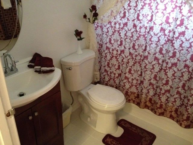 A cozy bathroom with a floral shower curtain and matching decor.