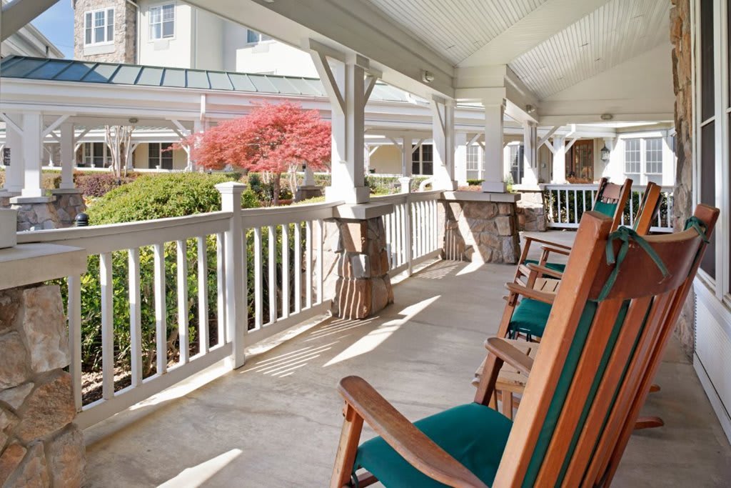 A peaceful porch with rocking chairs and a garden view.