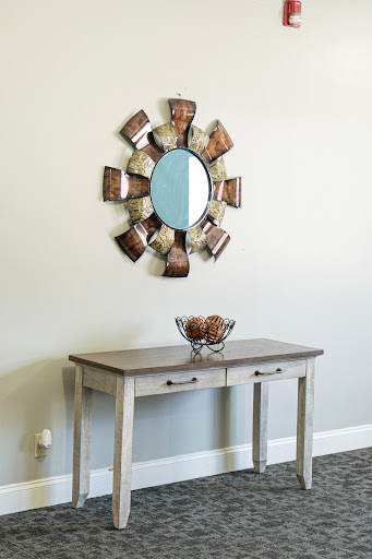 A stylish console table adorned with a decorative mirror and bowl, perfect for enhancing any entryway.