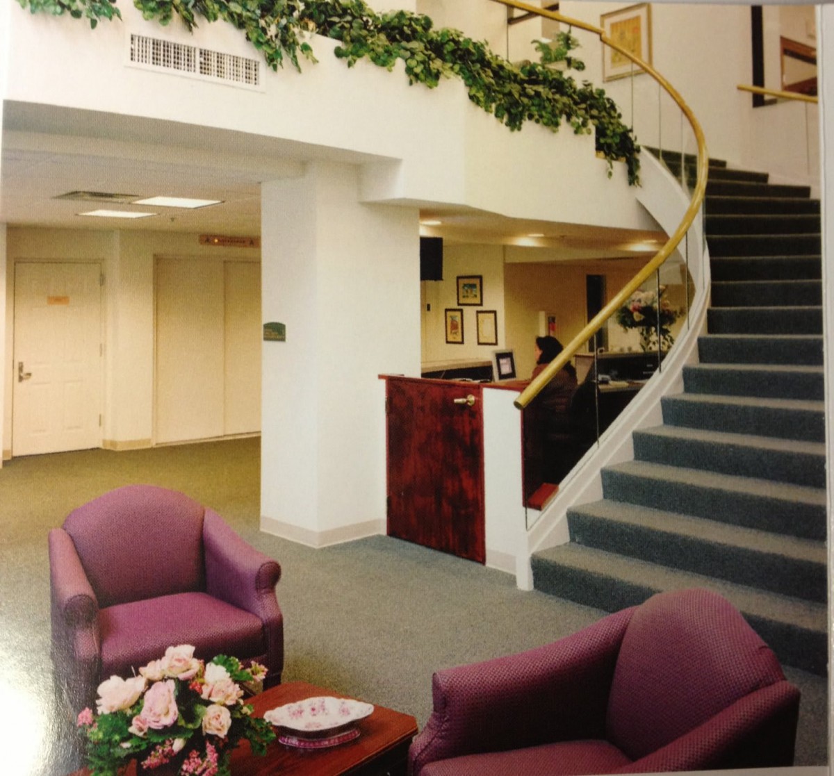 A lobby area with comfortable seating and a spiral staircase.