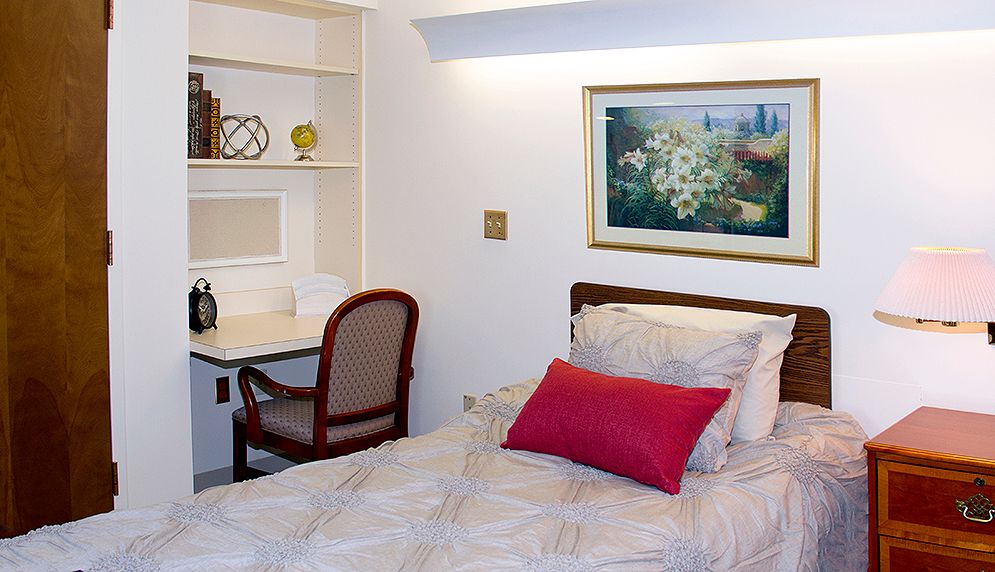 A cozy bedroom with a single bed, desk, and elegant decor.