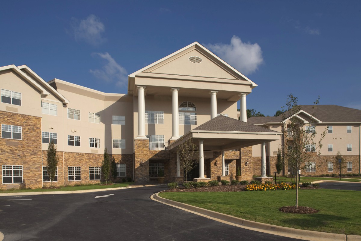 A large residential building with prominent columns and a circular driveway.
