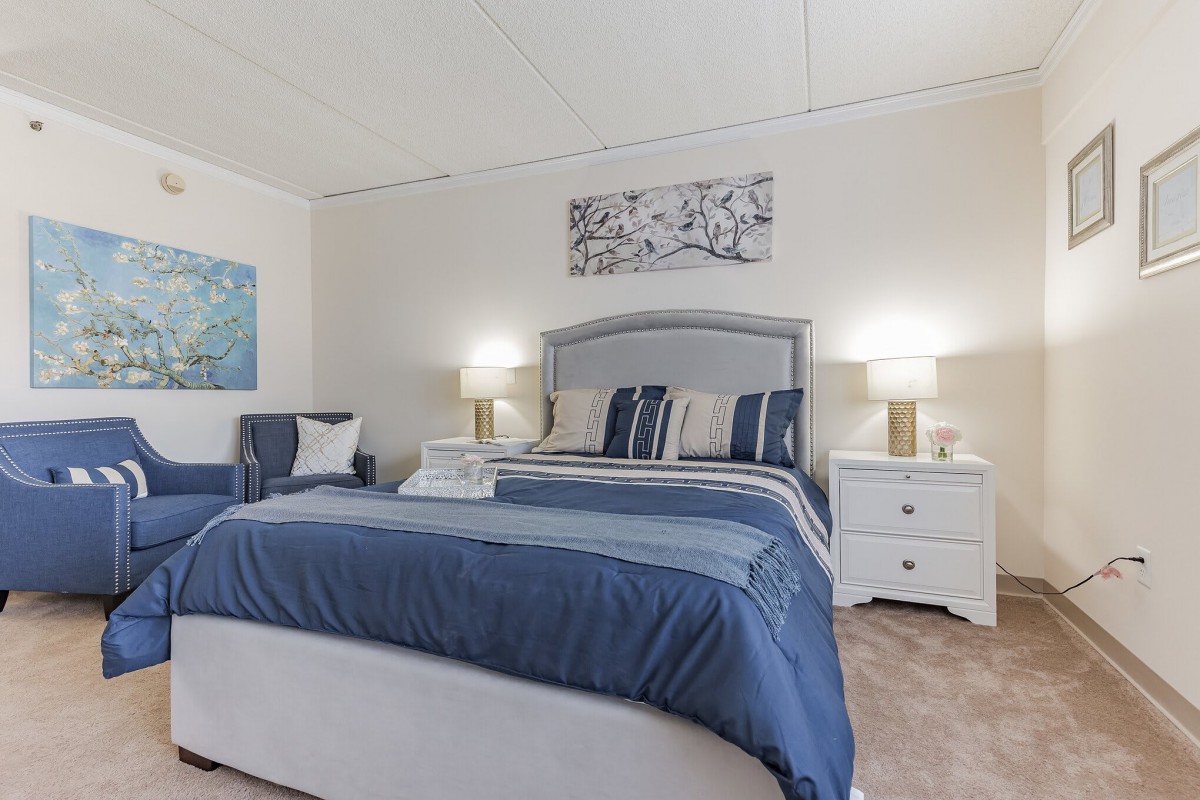 A beautifully decorated bedroom with blue bedding and elegant lamps on nightstands.