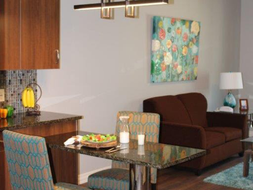 A cozy dining area featuring a sleek table, comfortable chairs, and vibrant artwork.