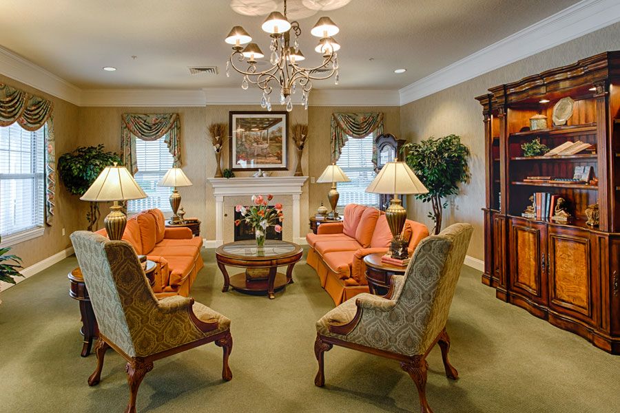 A traditional living room with elegant furnishings and a central chandelier.