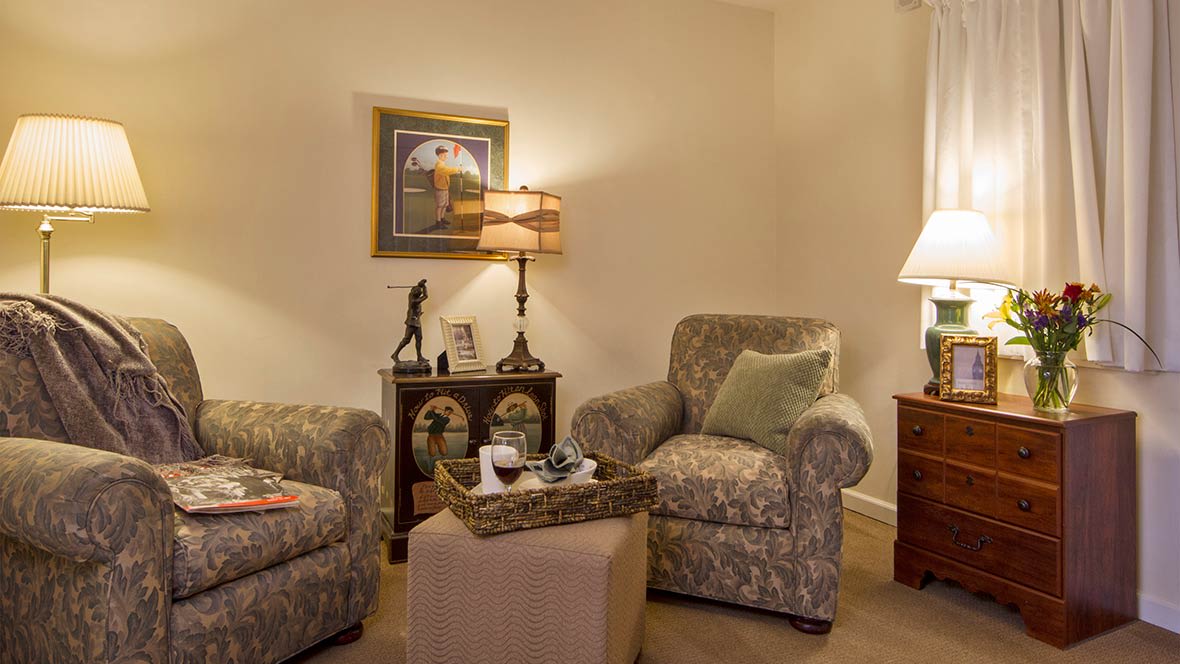A cozy living room with patterned armchairs and a warm ambiance.