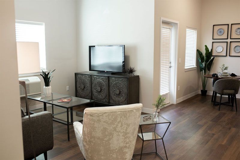 A modern, cozy living room with minimalist decor and a TV on a cabinet.