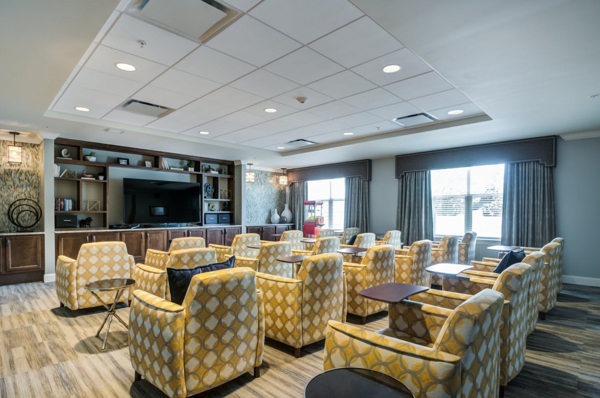 A cozy lounge area with patterned chairs and a television.