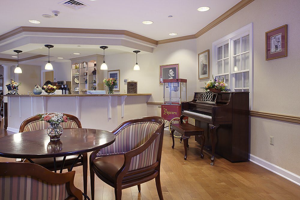 A cozy cafe interior featuring a piano and wooden seating area.