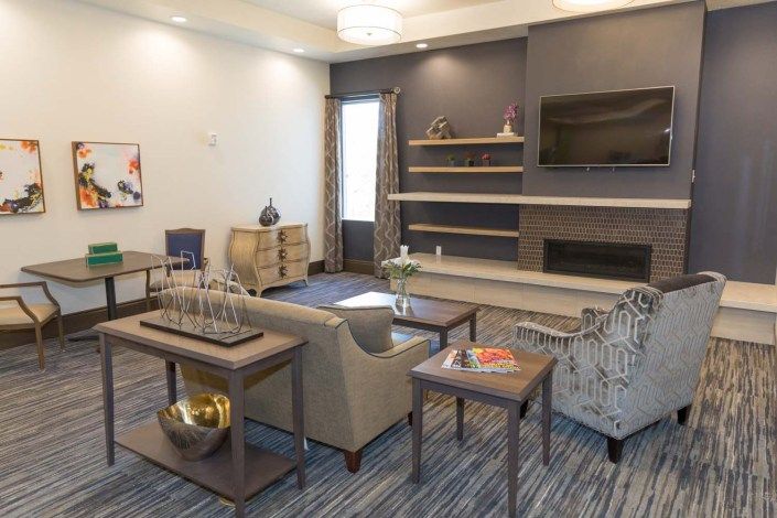 A modern living room featuring comfortable seating, built-in shelves, and contemporary decor.