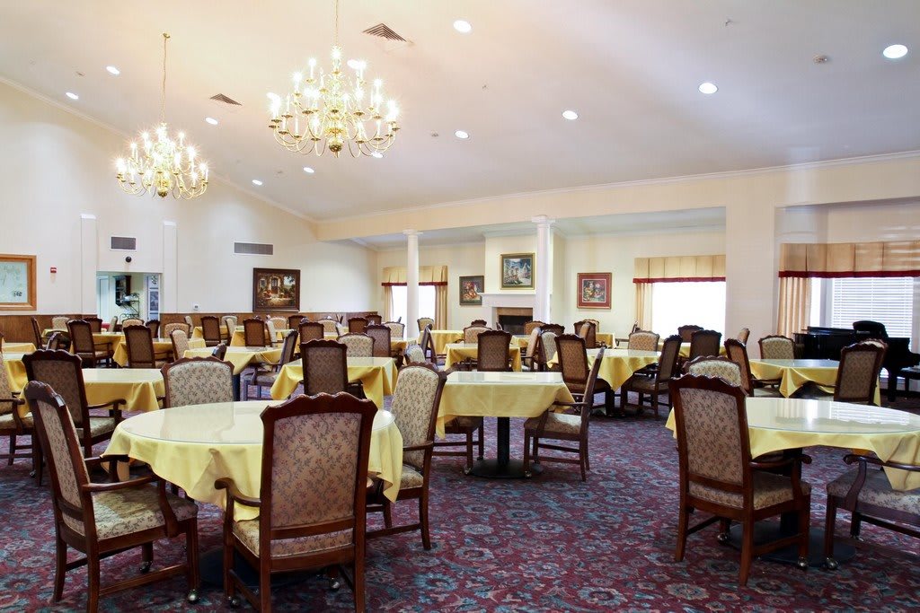 Elegantly set dining room with chandeliers and neatly arranged tables.