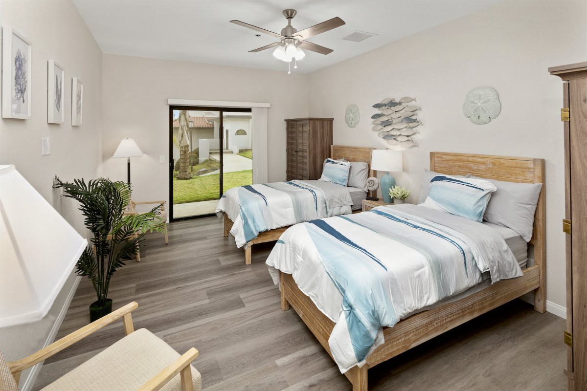 A cozy, modern bedroom with twin beds and ample natural light.