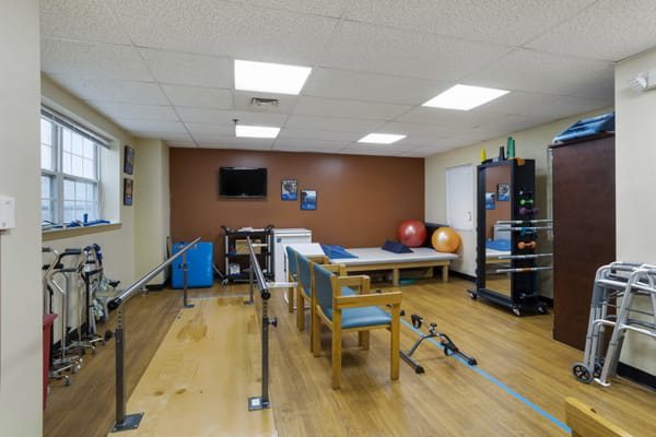A physical therapy room equipped with parallel bars and exercise equipment.