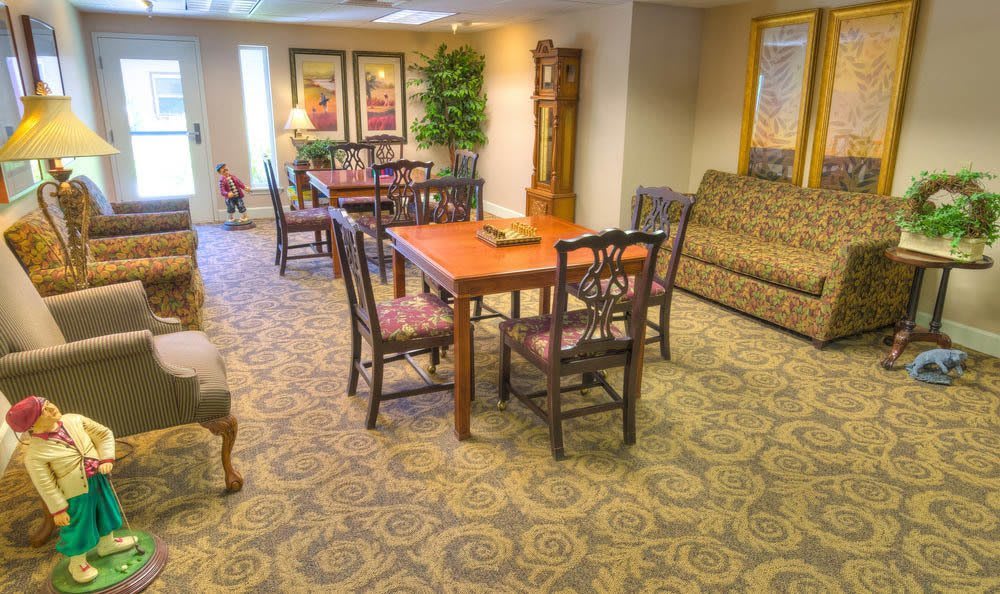 A cozy living room with a dining table and chairs, a sofa, and decorative elements.