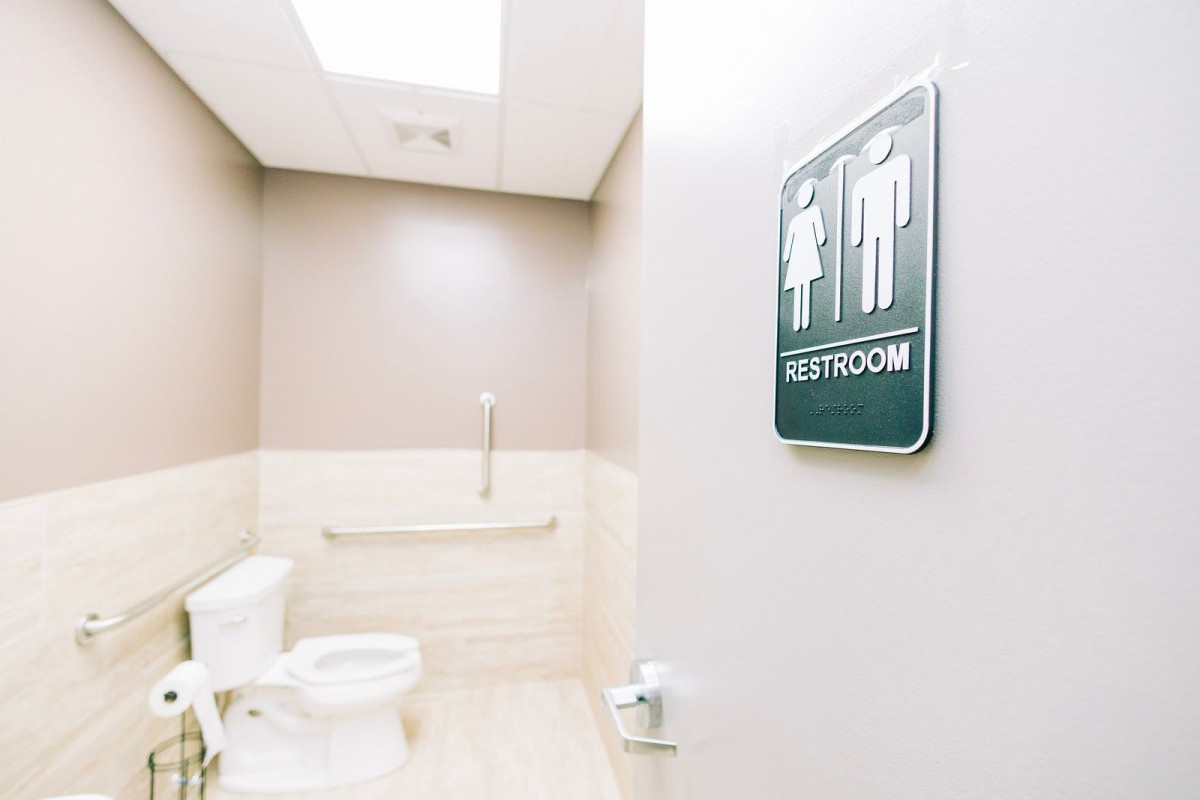 An accessible restroom with a sign on the door.