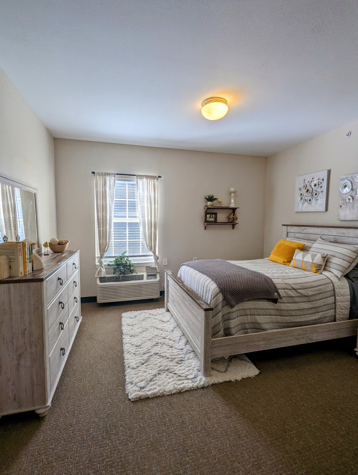 A modern and cozy bedroom with a neatly made bed, decorative pillows, and stylish wall art.