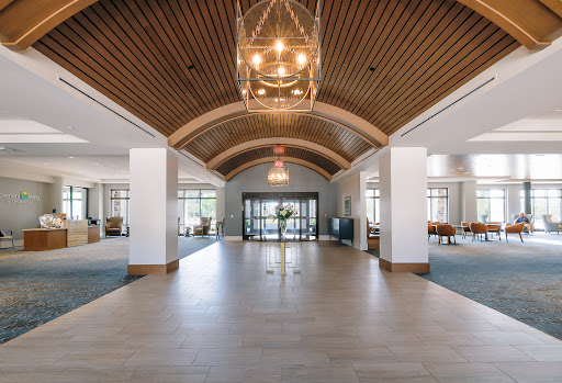 A spacious and elegantly designed lobby featuring a wooden arched ceiling and modern lighting.