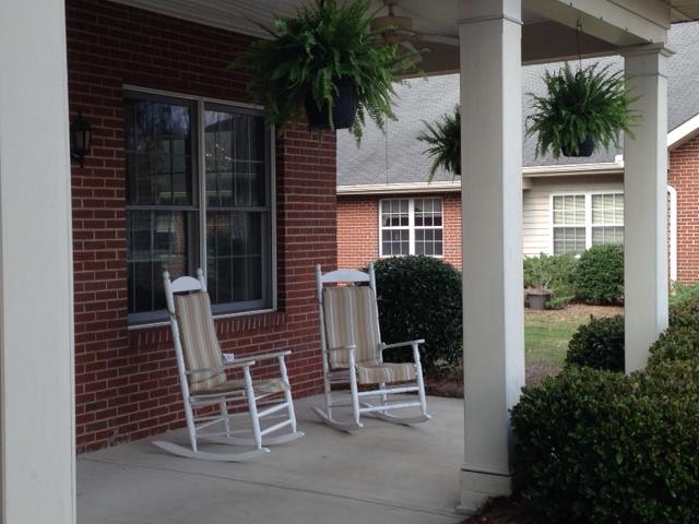 A cozy front porch with rocking chairs and hanging ferns.