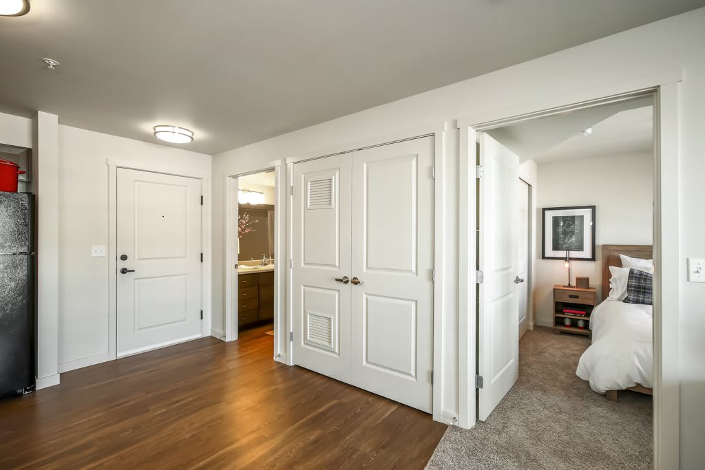 A modern hallway with wooden flooring and multiple doors leading to different rooms.