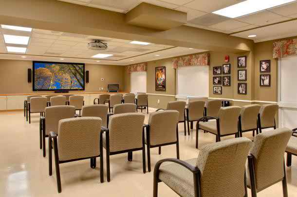 A well-organized conference room with rows of chairs and a presentation screen.