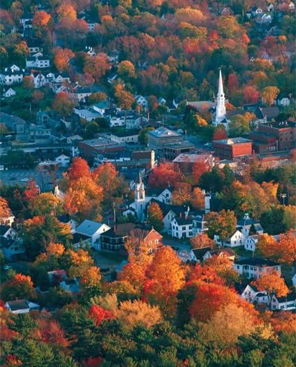 A picturesque aerial view of a town adorned with vibrant autumn foliage.