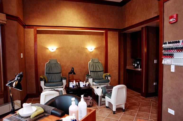 A serene spa setting with two pedicure chairs and warm, ambient lighting.