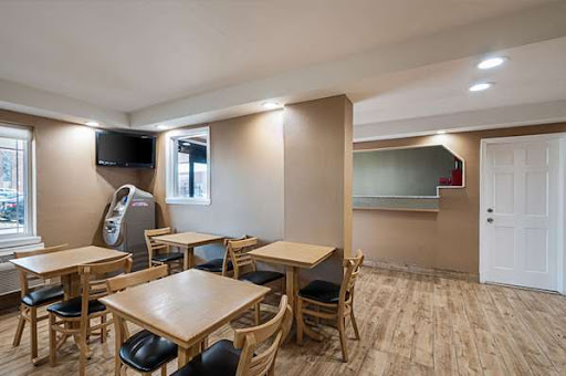A modern and minimalistic dining area in a cafe, featuring wooden tables and chairs.