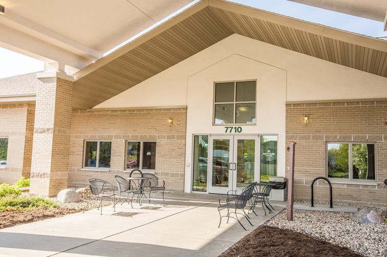 An exterior view of a building with a patio and outdoor seating area.