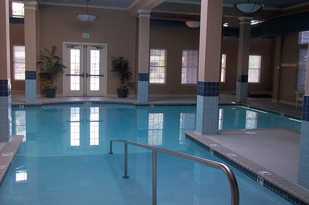An indoor swimming pool with clear blue water and elegant columns.