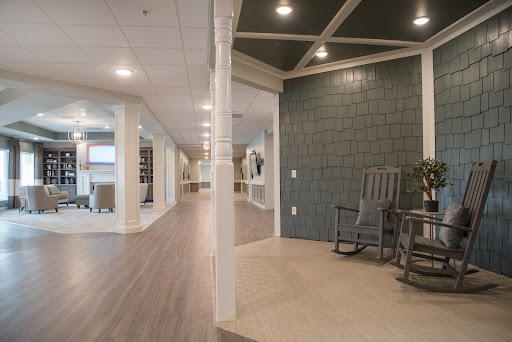 A modern lobby featuring a green accent wall and comfortable rocking chairs.