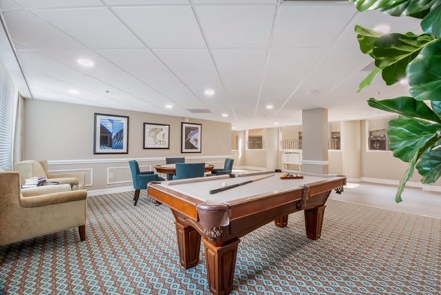 A spacious game room featuring a pool table and seating area.