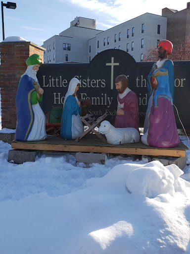 A colorful nativity scene displayed outdoors, set against a snowy backdrop.