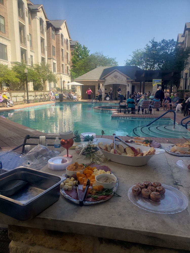 A poolside event with a variety of snacks and refreshments under the clear sky.