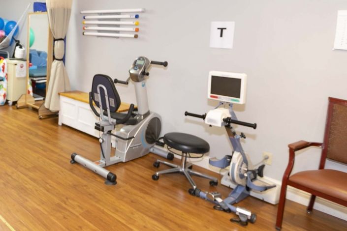 A room featuring various gym equipment used for physical therapy and rehabilitation exercises.