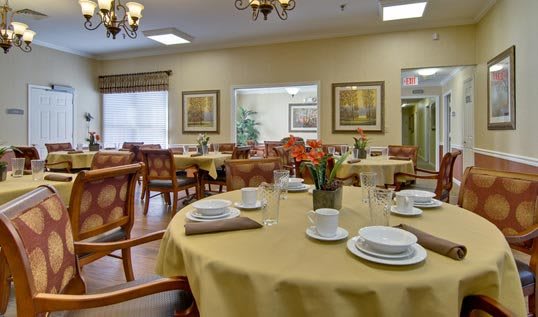A cozy dining room with elegantly set tables and chairs, ready for guests.