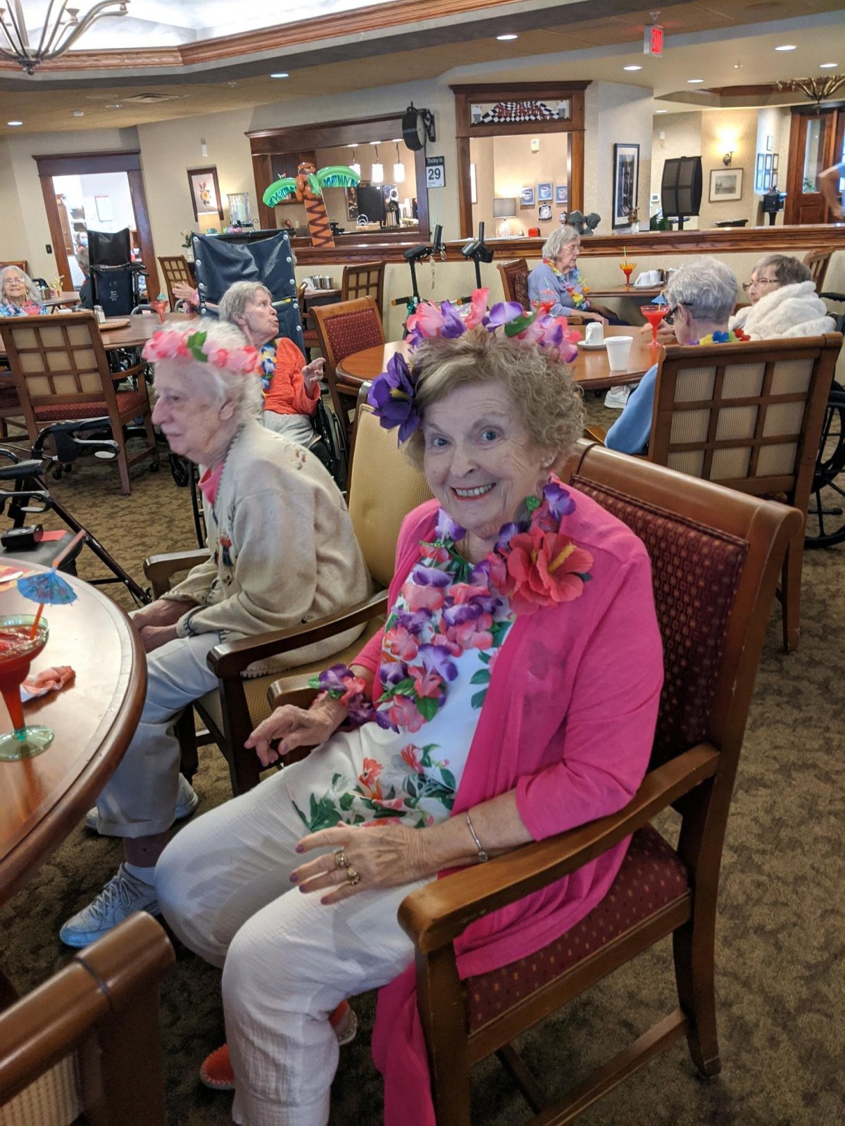 Elderly women enjoying a festive gathering with floral decorations.