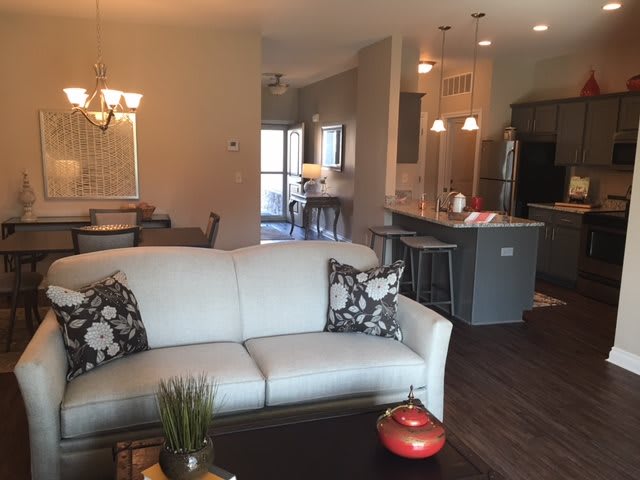 A modern open floor plan with a cozy living room leading into a kitchen and dining area.